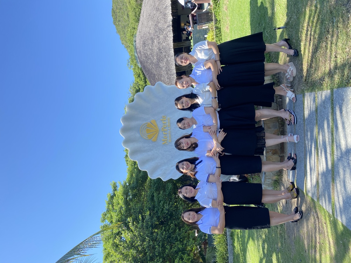 Groupe de femmes devant sculpture coquillage resort